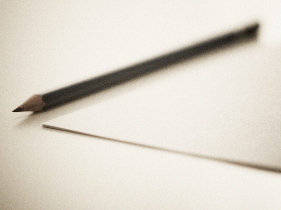 Een potlood naast de hoek van een onbeschreven vel papier